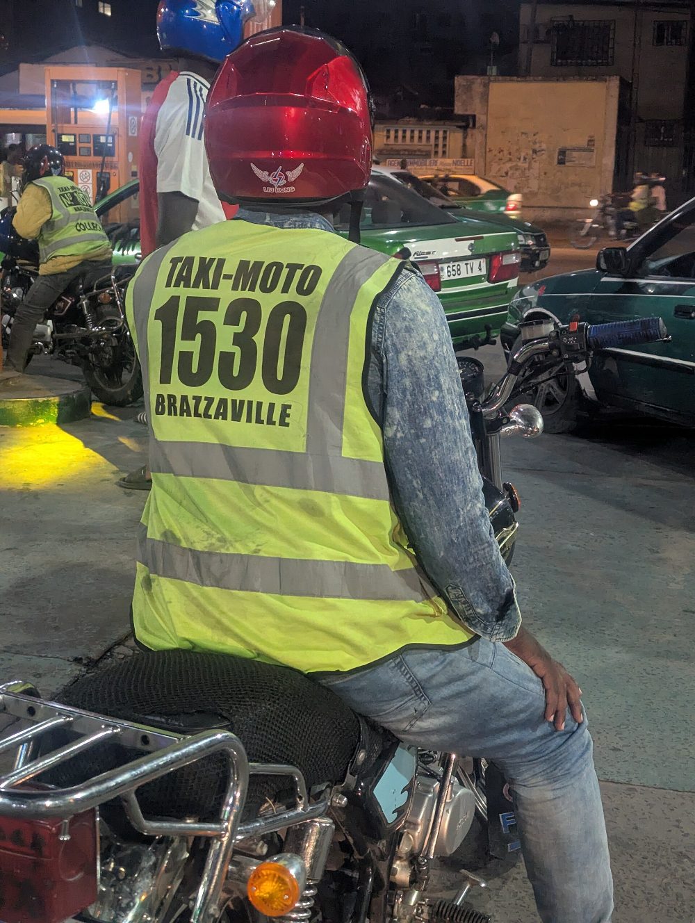 Coursier à moto, gilet réfléchissant, Kinshasa de nuit